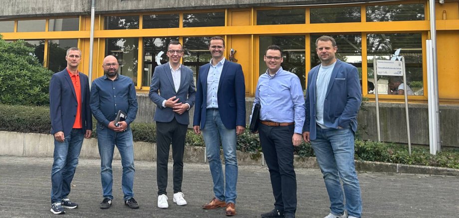 Sechs Personen haben sich vor der Vogelsbergschule in Lauterbach zum Gruppenbild aufgestellt und lächeln in die Kamera.