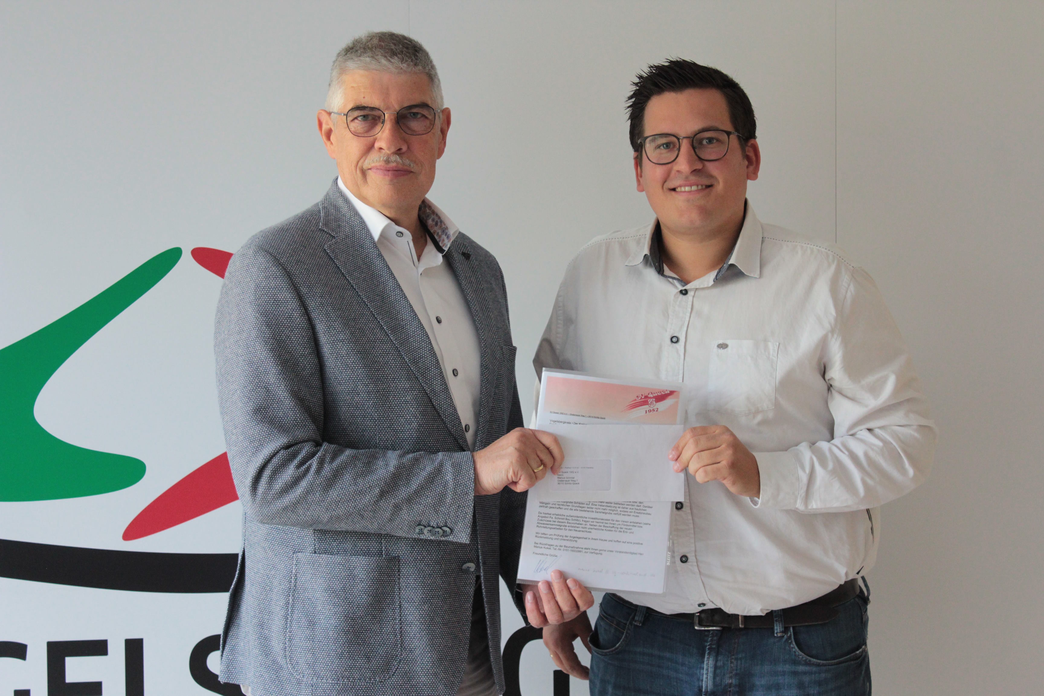 Der Neubau der Schmutzwasser-Sammelgrube ist dank der OVAG gesichert. Marius Kokel, Mitglied im Vorstand des SV Queck, freut sich über eine Spende in Höhe von 2000 Euro, die Landrat Manfred Görig übergibt. 