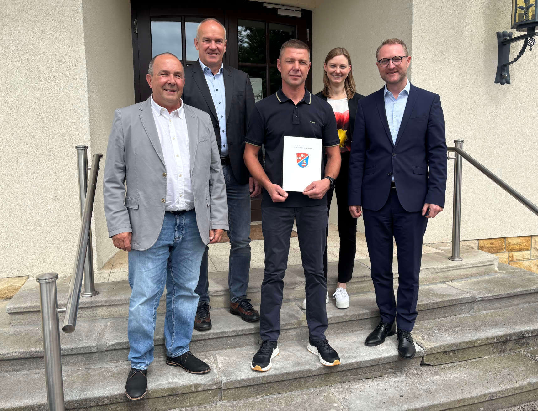 Landrat Dr. Jens Mischak (rechts) übergibt gemeinsam mit Matthias Steckenreuter (von links), Regionalmanagement beim Verein Region Vogelsberg, Edwin Schneider, Vorsitzender des LEADER-Beirats, und Jana Brittner, Leiterin des Sachgebiets Dorf- und Regionalentwicklung im Amt für Wirtschaft und den ländlichen Raum des Vogelsbergkreises, einen Förderbescheid an Arthur Lachenmaier.