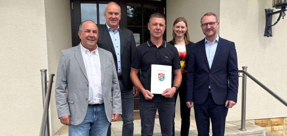 Landrat Dr. Jens Mischak (rechts) übergibt gemeinsam mit Matthias Steckenreuter (von links), Regionalmanagement beim Verein Region Vogelsberg, Edwin Schneider, Vorsitzender des LEADER-Beirats, und Jana Brittner, Leiterin des Sachgebiets Dorf- und Regionalentwicklung im Amt für Wirtschaft und den ländlichen Raum des Vogelsbergkreises, einen Förderbescheid an Arthur Lachenmaier.