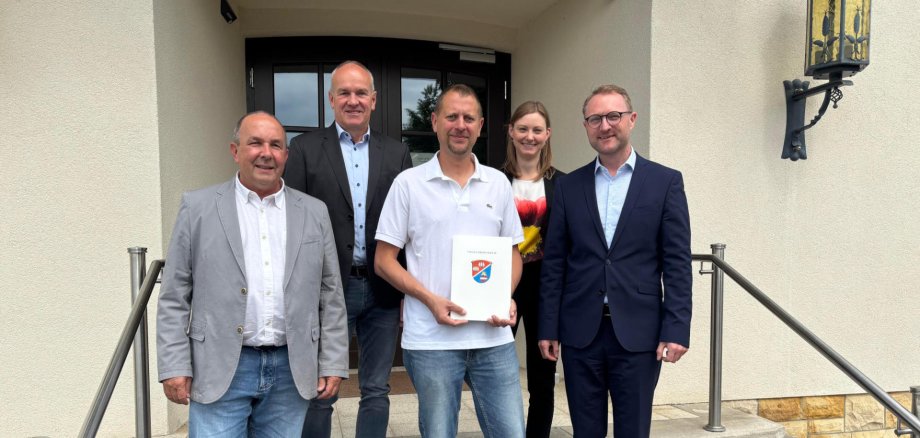 Landrat Dr. Jens Mischak (rechts) übergibt gemeinsam mit Matthias Steckenreuter (von links), Regionalmanagement beim Verein Region Vogelsberg, Edwin Schneider, Vorsitzender des LEADER-Beirats, und Jana Brittner, Leiterin des Sachgebiets Dorf- und Regionalentwicklung im Amt für Wirtschaft und den ländlichen Raum des Vogelsbergkreises, einen Förderbescheid an Jens Lerner aus Hartershausen.