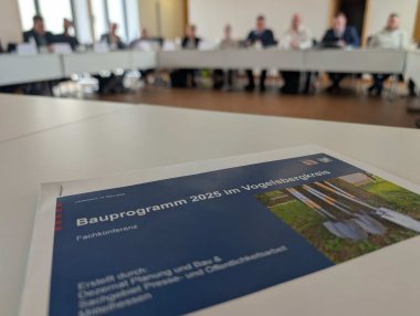 Nahaufnahme eines Handouts. Darauf steht Straßenbaukonferenz 2025 von Hessen Mobil
