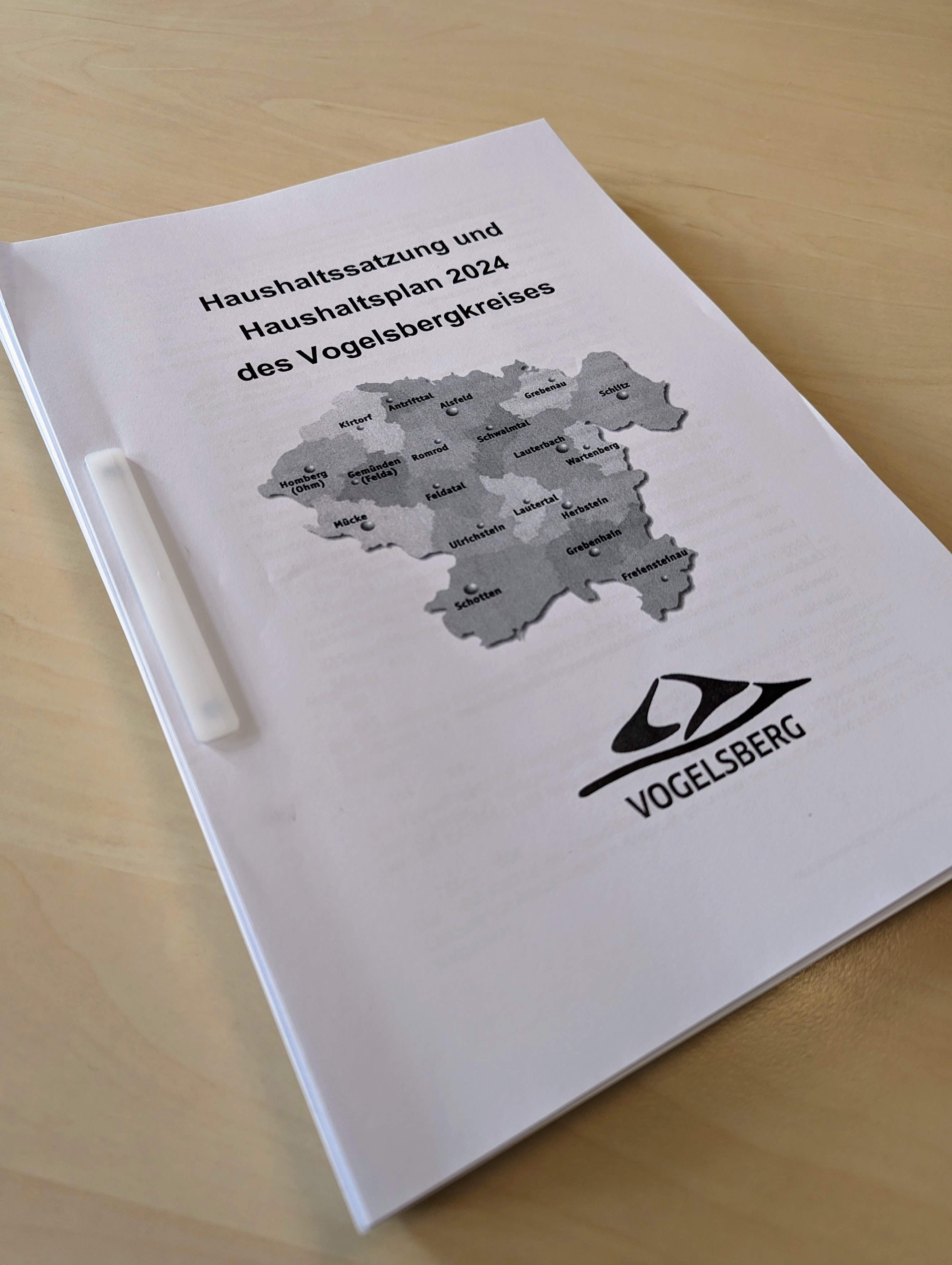 Der Haushaltsentwurf 2024 liegt auf einem Schreibtisch. Einige hundert zusammengeheftete Seiten sind zu sehen.