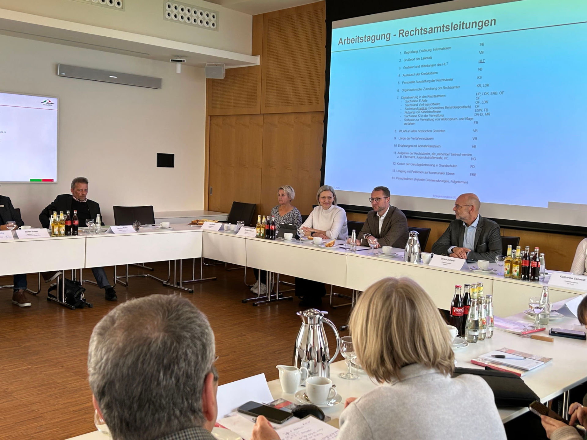 Eine Gruppe von Menschen sitzt in einem Sitzungssaal.  