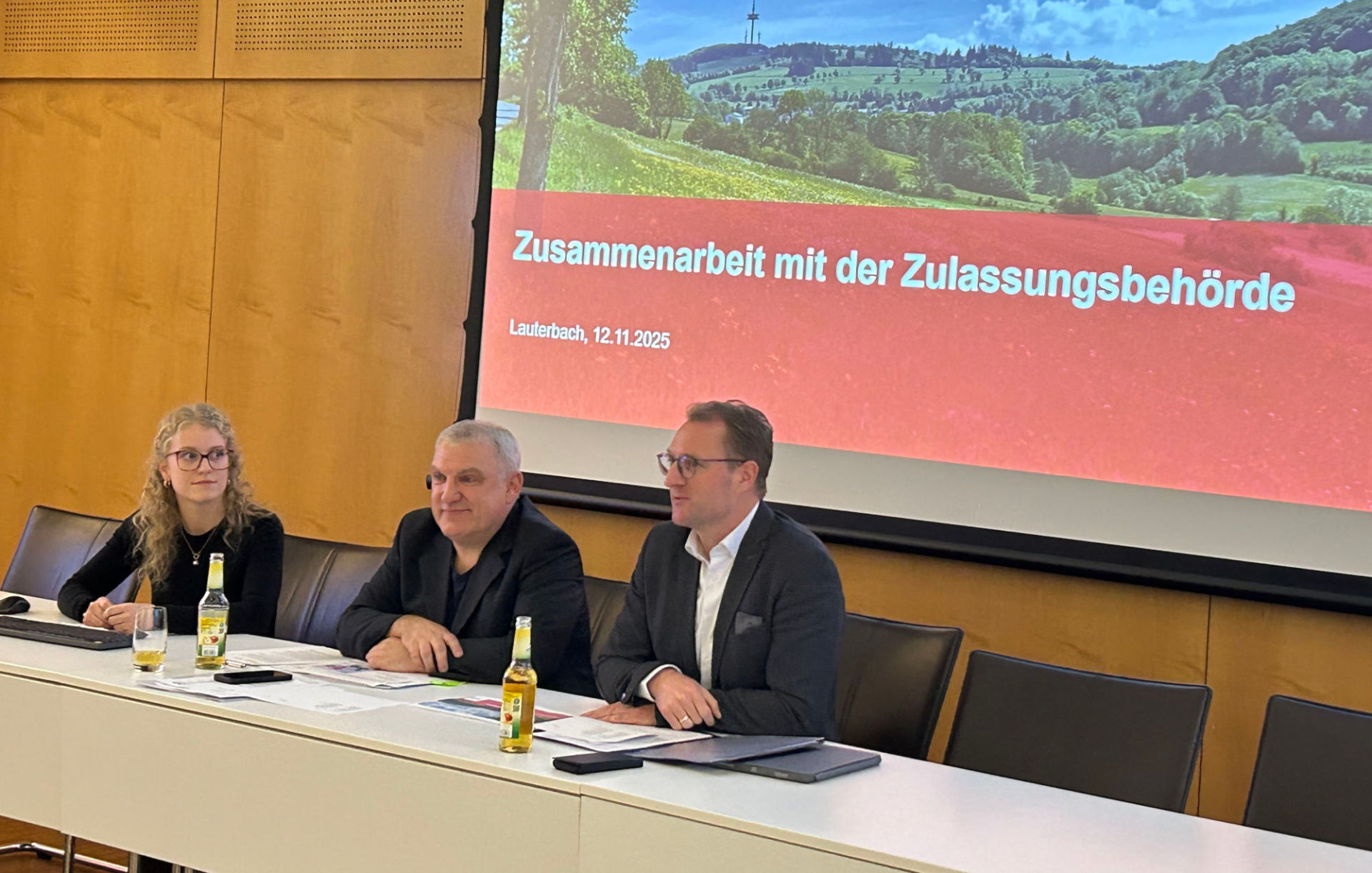 Landrat Dr. Jens Mischak, Amtsleiter Peter Sukdolak und Luisa-Marie Schübeler informieren über internetbasierte Fahrzeugzulassungen.