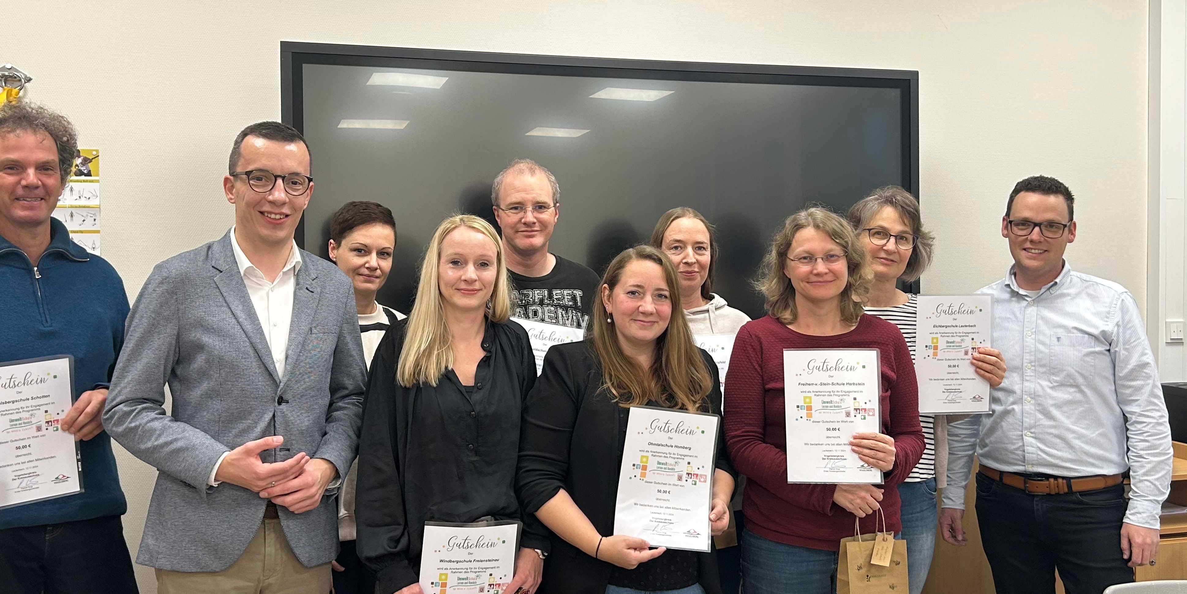 Erster Kreisbeigeordneter Patrick Krug (Zweiter von links) und Matthias Röse, der Leiter des Amtes für Schulische Bildung und Betreuung (rechts) gratulieren den Lehrerinnen und Lehrern aus den ausgezeichneten Umweltschulen.