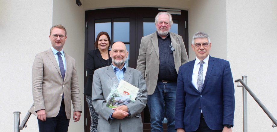 Michael Hebel (unten, Mitte) wurde nach 40 Jahren Arbeit beim Vogelsbergkreis von Landrat Manfred Görig (rechts), dem Ersten Kreisbeigeordneten Dr. Jens Mischak (links), Dagmar Scherer, Leiterin des Jugendamts und Michael Facius, Leiter des Sachgebiets Besondere Soziale Dienste, in den Ruhestand verabschiedet. 
