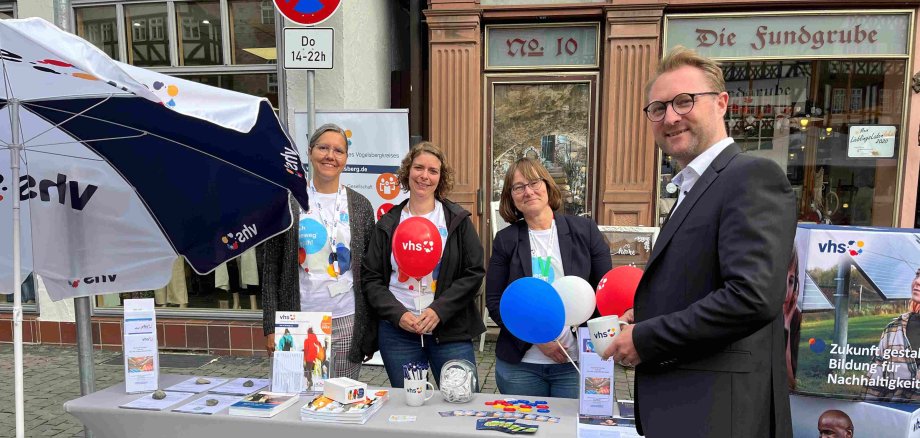 Dr. Jens Mischak steht an einem Info-Stand der volkshochschule in Alsfeld. GEmeinsam mit Monika Schenker, der Amtsleiterin, und zwei Mitarbeiterinnen