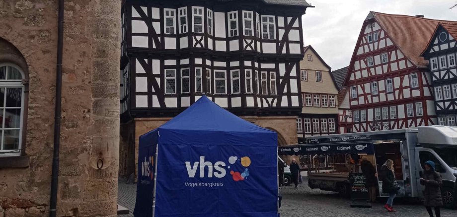 Schon zu Beginn des Jahres war die vhs auf dem Alsfelder Wochenmarkt vertreten. Am Freitag, 28. August, haben Interessierte dort wieder die Möglichkeit, das Herbstsemester-Programm zu entdecken. Auf dem Foto ist ein blaues vhs-Pavillon vor dem Alsfelder Marktplatz zu sehen.