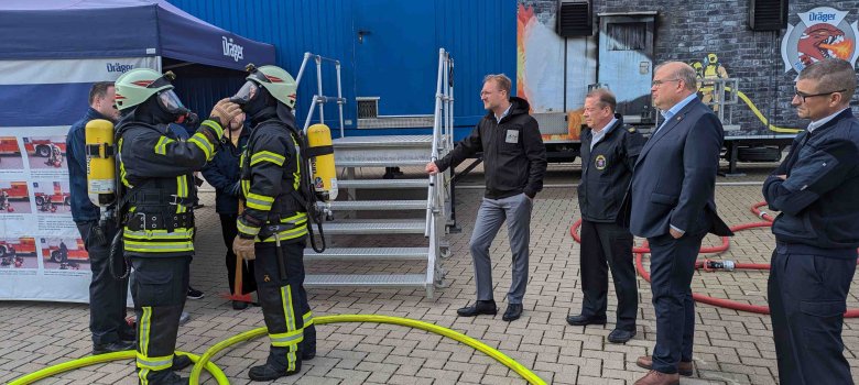 Zwei Feuerwehrleute kontrollieren gegenseitig ihre Atemschutzausrüstung.
