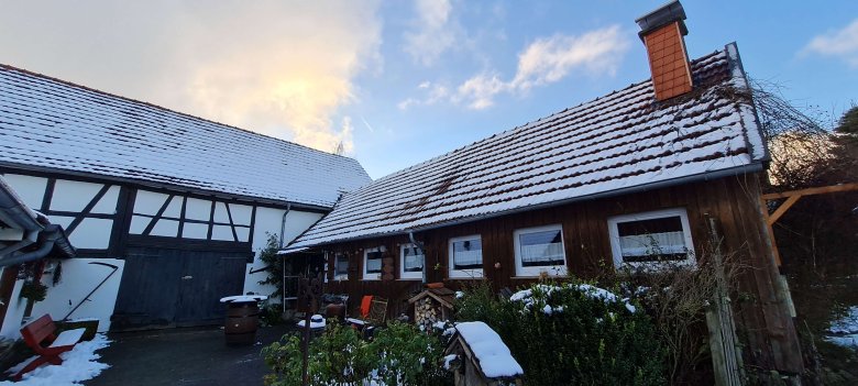 Zwei Schneebedeckte Dächer, blauer Himmel und ein Veranstaltungsraum für etwa 20 Personen: Auch Verkostungen gibt es bei „Vulkan Likoer und Gelee“ in Metzlos. Im Anbau, in dem auch die Produktion untergebracht ist, gibt es Fruchtaufstriche, Liköre, Waffeln, Fladenbrot und herzhafte Aufstriche zum Probieren. (Foto: Vogelsbergkreis/C.Lips)