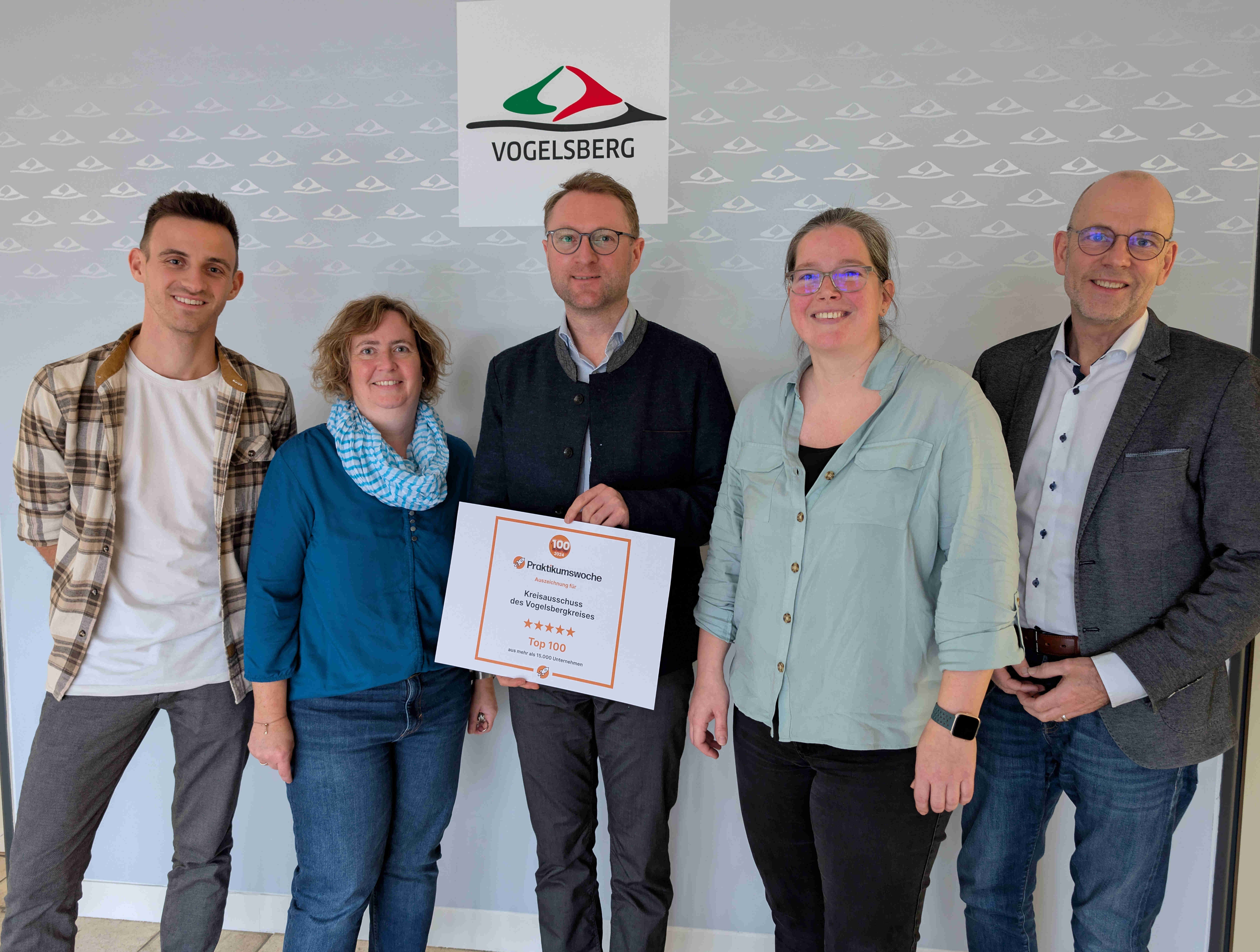 Landrat Dr. Jens Mischak (Mitte), präsentiert gemeinsam mit Haupt- und Personalamtsleiter Ulrich Schäfer (von rechts), seiner Stellvertreterin Melanie Ahne sowie den Ausbildungsleitungen Silke Winter und Timo Walper stolz die Urkunde. Der Vogelsbergkreis hat sich unter rund 15.000 Unternehmen und Institutionen besonders hervorgetan: Er ist einer von 100 Top-Praktikumsplätzen. 
