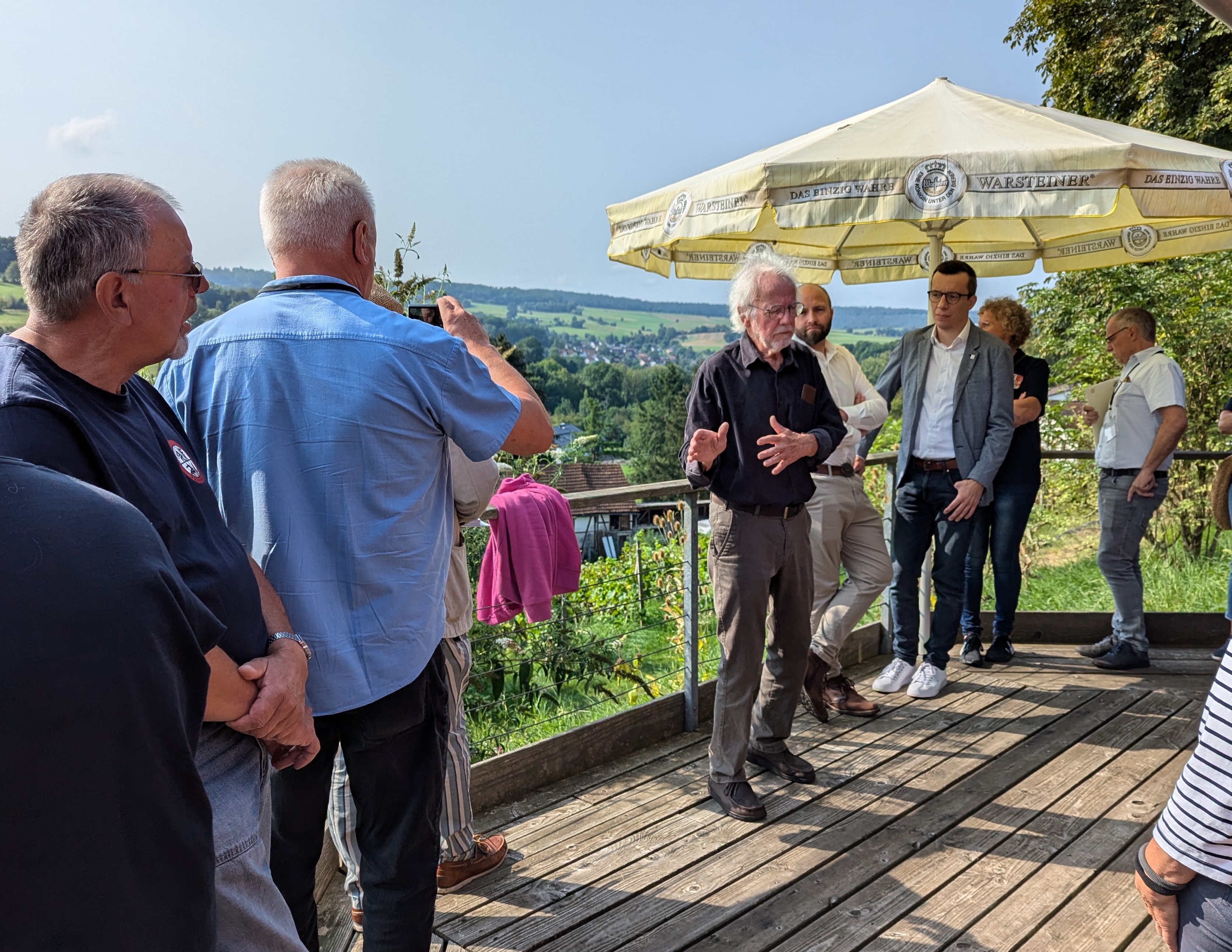 Georg-Peter Hagedorn (Mitte) erläuterte Erstem Kreisbeigeordneten Patrick Krug (Vierter von rechts), Bürgermeister Benjamin Göbl sowie den Mitgliedern der Jury die Arbeit des Vereins „Weinbergfreunde Wingershausen“.