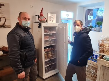 Mario Hanisch und Jens Ziegenhain im Hofladen. Sie stehen vor dem offenen Tiefkühlschrank. DArin sind Fleischprodukte zu sehen.