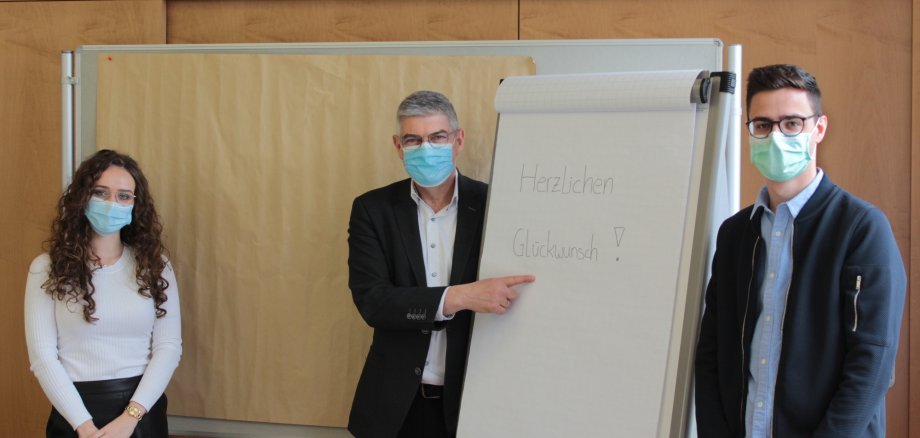 Landrat Görig gratuliert Laura Wiegand und Florian Steuernagel zur bestandenen Abschlussprüfung.