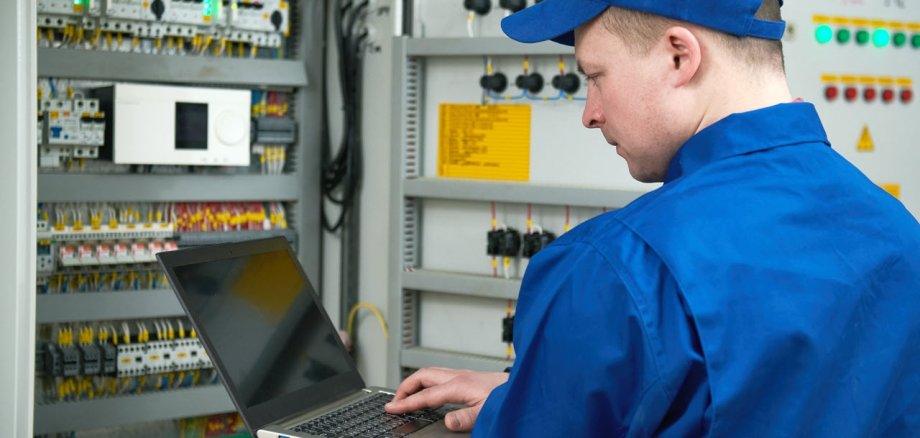 Electrician works with tester in switchbox